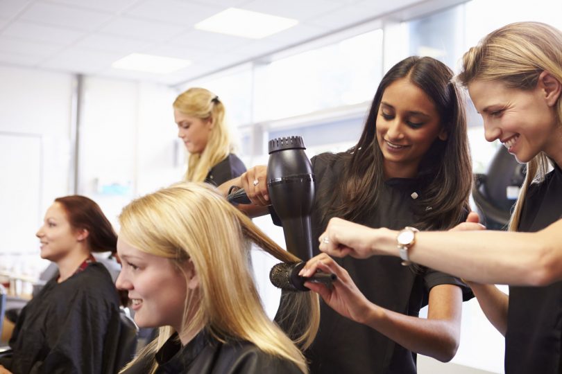 Hairdresser showing an apprentice how to style hair