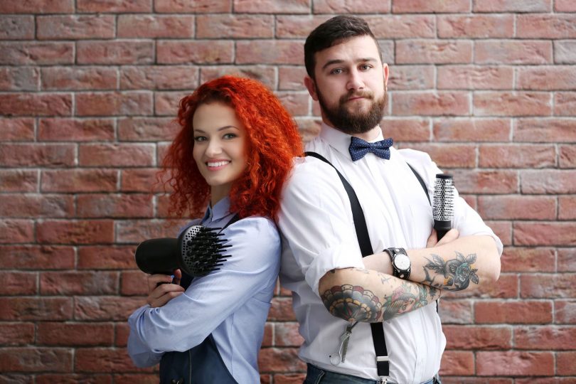 A hairdresser and barber standing back to back