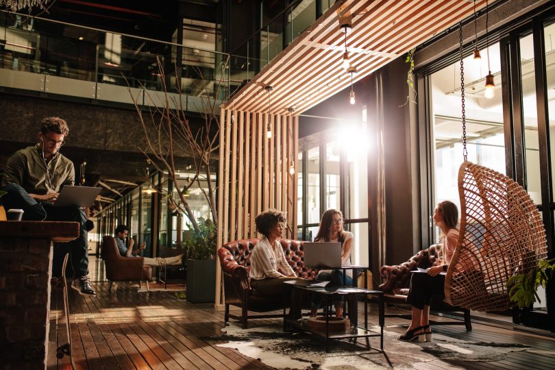 Office interior with people chatting and working